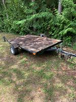 Angled view of entire trailer parked on grass near trees