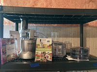 Food processor, attachments and cookbooks arranged on shelving