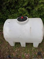 Full side view of the white tank showing cylindrical body, molded support legs and black/red lid.
