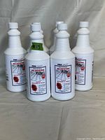 Six white plastic bottles of Pro Shot Industrial Re-Newing Floor Restorer & Finish displayed upright.
