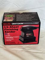 Photo of the front side of the boxed Craftsman 1/4 Sheet Finish Sander showing model number 211607 and key features.