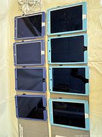 Eight iPad Air 2 tablets laid out face up in two rows, showing front screens and cases.