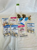 Photo of all 8 SharkBite fittings and valves laid out on white background including two ball valves and six push-to-connect fittings in packaging.