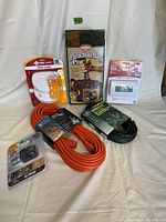 Image showing all items in the lot: extension cords, smoke alarms, thermostat, parachute bag