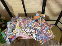 Photo showing a pile of more than 60 Marvel comic books with various titles and characters on the covers including The Punisher, Silver Surfer, Cyclops.