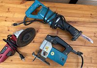Overview of 3 power tools including a reciprocating saw, jigsaw, and angle grinder on wooden surface
