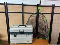 Fishing tackle box and rubber fishing net together showing size and condition