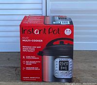 Box of Instant Pot Duo Multi-Cooker showing brand, model, and features, 7-in-1 cooker with 6 quarts capacity.