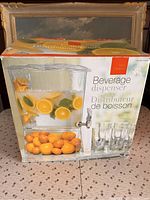 Box front showing beverage dispenser with fruit inside and four drinking glasses.