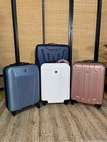 Four Swiss Gear luggage pieces grouped together showing size and color differences.