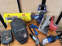 Photo showing the full collection of tools including the welding helmet, clamps, power tools, and box.