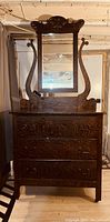 Front view of the antique dresser with attached mirror showing detailed wood grain and ornate frame
