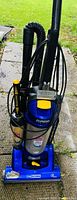 Full view of blue Eureka upright bagless vacuum cleaner with attached duster combo attachments and hose.