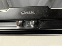 Close-up image of the ACCO brand embossed on the metal handle of the hole puncher showing wear and minor rust spots.