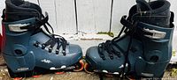 Side view of pair of men’s size 9 roller blades showing blue shell with black cuff and orange wheels.