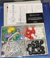 Photo showing the Old Nobby molecular kit components including multicolored atom spheres and connectors inside plastic compartments.