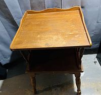 Full view of the vintage wooden side table showing wear