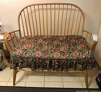 Front view of wooden bench with floral seat cushion