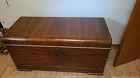 Full view of the wooden Boshart cedar chest showing its rectangular shape, wood finish, and general condition.