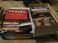 Box of assorted DVDs including Friends Complete Series and other various titles