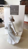 Porcelain female ice skater figurine with glaze finish and box marked Royal Doulton Classics.