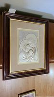 Framed sterling silver embossed artwork of the Holy Family, showing full piece in dark wooden frame.