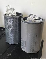 Two Swarovski crystal figurines on top of decorative Swarovski boxes. One is a swan and the other is a four-leaf clover.