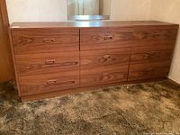 Full front view of the teak 6-drawer dresser showing all drawers closed and visible integrated handles.