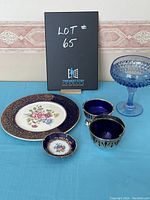 Photo showing all items including blue glass compote, two cobalt blue creamers with silver holders, a small floral dish, and large floral plate.