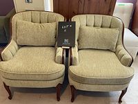 Front view of both chairs, showing upholstery and wood trim