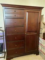 Front view of walnut gentleman's chest with six drawers left side and paneled cabinet door right side.