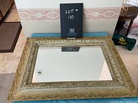 Top view of the rectangular mirror showing ornate carved frame with distressed finish and visible wear.