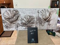 Front view of large rectangular floral canvas print depicting three large flowers with textured and abstract background text