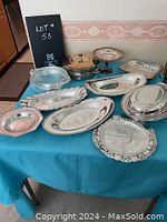 Lot #53 including vintage and used assorted silverplate serving pieces such as platters, trays, a covered serving dish, pedestal bowls, and trays with ornate edges.