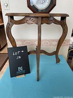 Full view of the telephone table highlighting Queen Ann style carved legs and decorative apron details.