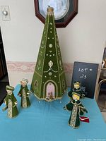 Full view of vintage green velvet Christmas tree and four matching green velvet figurines on a blue tablecloth with a lot number sign