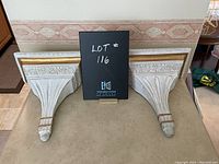 Pair of vintage white and gold wall sconces with detailed carving and paint finish, shown from front and top angles