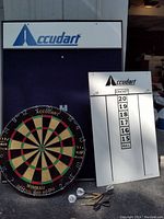 Photo of the entire set including the dart board, scoreboard, darts, and wall mount frame with ACCUDART branding.