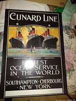 Photo of a framed Cunard Line print showing three ocean liners and advertising fastest ocean service.