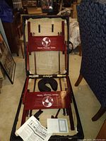 Full view of foldable wooden Master Massage Table with brand logo visible, folded open showing padded face cradle and parts of frame.