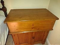 Closed view of the pine dry sink showing rectangular top and lower cabinet doors.