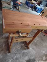 Front right perspective view of bench showing top surface, legs and vise