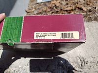 Sticker on damaged box stating 'Sarah's Garden Christmas Hors D'Oeuvre Try 11.8xD' with barcode, green and red colored box sides visible.