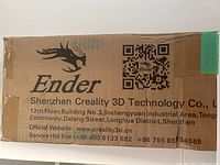 Cardboard box panel with 'Ender' logo, Shenzhen Creality address and QR code