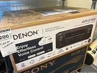 Front of Denon AVR-S750H box showing brand name, model and voice control features