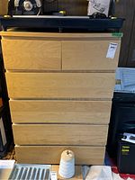 Front view of the light wood laminate dresser with six drawers, showing its size and drawer layout.