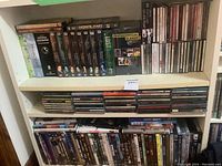 Full view of two shelves showing DVD sets, boxed sets and rows of music CDs