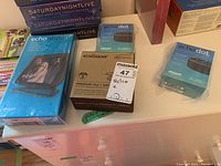 Photo showing two Echo Dot boxes, one Echo Show box, and one EchoGear mount box on a dresser