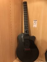 Front view of guitar leaning in wooden shelf