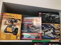 Four LEGO boxes displayed on shelf: Wall-E, Crazy Action Contraptions, Technic and Creator 3-in-1